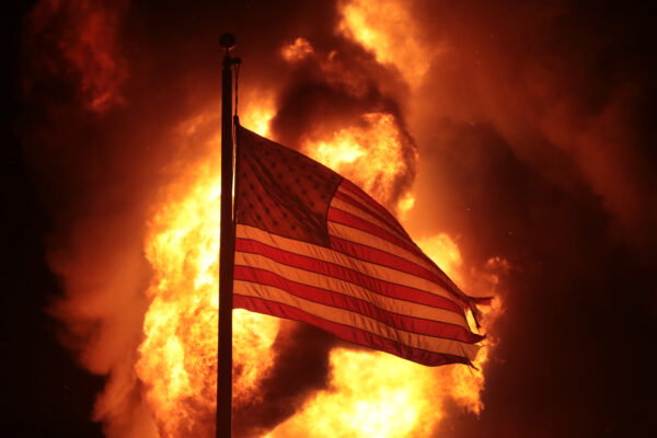 A flag flies in front of a department of corrections building after it was set ablaze during a second night of rioting in Kenosha, Wis. on Aug. 24, 2020. (Scott Olson/Getty Images)