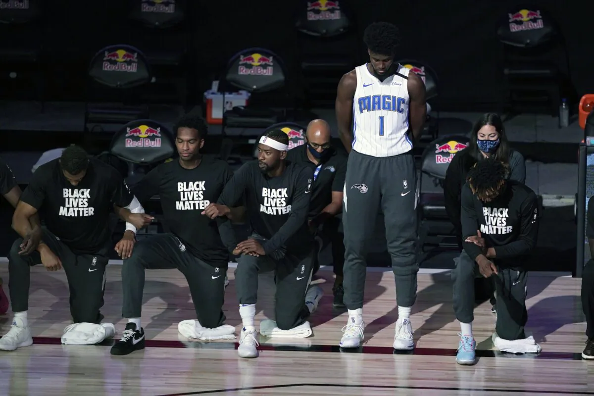 Orlando Magic's Jonathan Isaac (1) stands as others kneel before the start of an NBA basketball game between the Brooklyn Nets and the Orlando Magic in Lake Buena Vista, Fla., on July 31, 2020. (Ashley Landis/Pool/AP Photo)