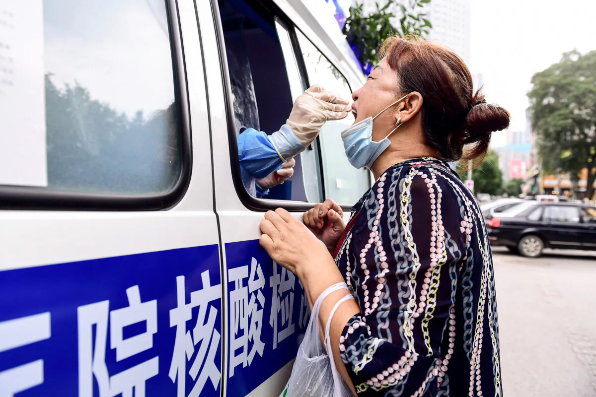 A health worker carries out a COVID-19 test on a resident in a testing vehicle in Shenyang in China's northeastern Liaoning Province on July 29, 2020. (STR/AFP via Getty Images)