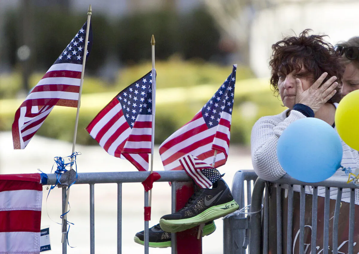 A woman wipes a tear at a memorial for the victims of the Boston Marathon bombing on Boylston Street near the race finish line in Boston on April 22, 2013. (Robert F. Bukaty/AP)
