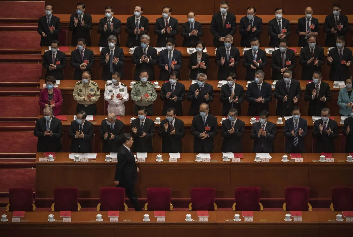 Chinese leader Xi Jinping (bottom) arrives at the closing session of the Chinese regime’s rubber-stamp legislature conference while other Communist Party officials applaud, in Beijing, on May 28, 2020. (Kevin Frayer/Getty Images)