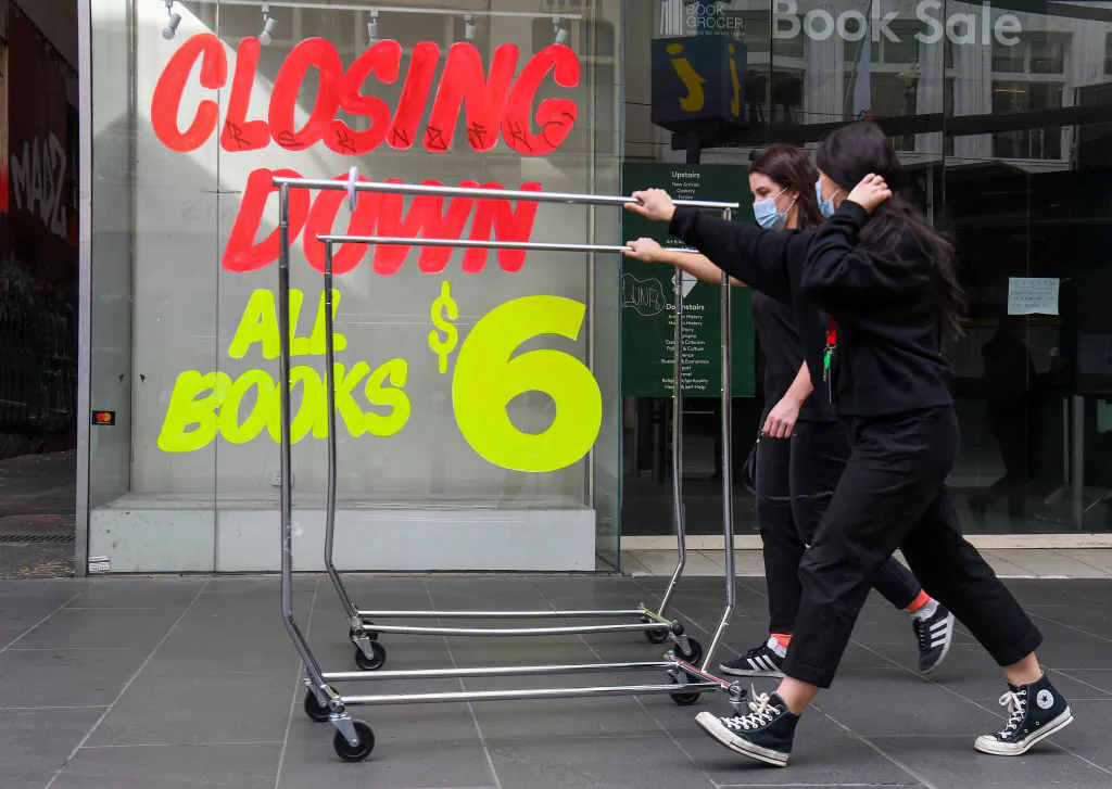 Workers push trolleys past an empty shop in Melbourne's central business district on August 3, 2020 after the state announced new restrictions as the city battles fresh outbreaks of the COVID-19 coronavirus. (William West/AFP via Getty Images)