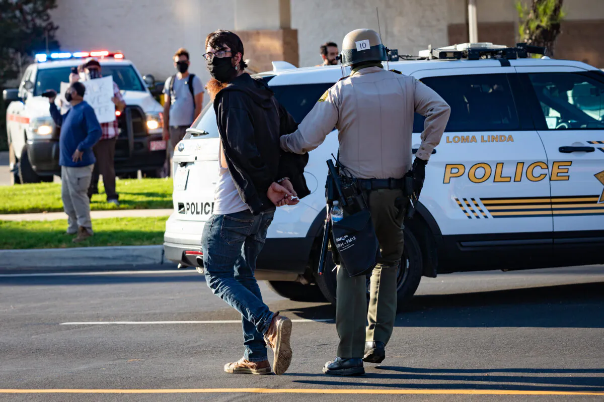 A protester is arrested in Yucaipa, Calif., on Aug. 1, 2020. (John Fredricks/The Epoch Times)