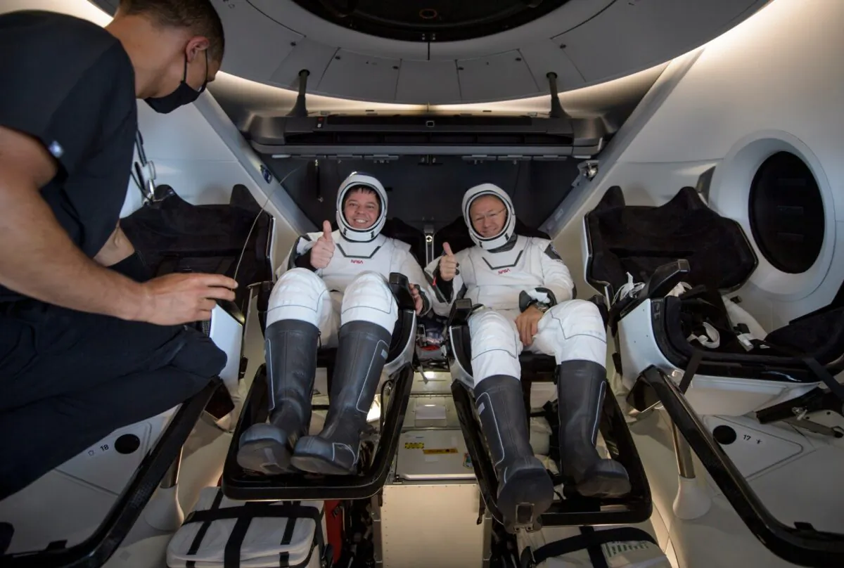 NASA astronauts Robert Behnken (L) and Douglas Hurley are seen inside the SpaceX Crew Dragon Endeavour spacecraft onboard the SpaceX GO Navigator recovery ship shortly after having landed in the Gulf of Mexico off the coast of Pensacola, Fla., on Aug. 2, 2020. (Bill Ingalls/NASA via AP)