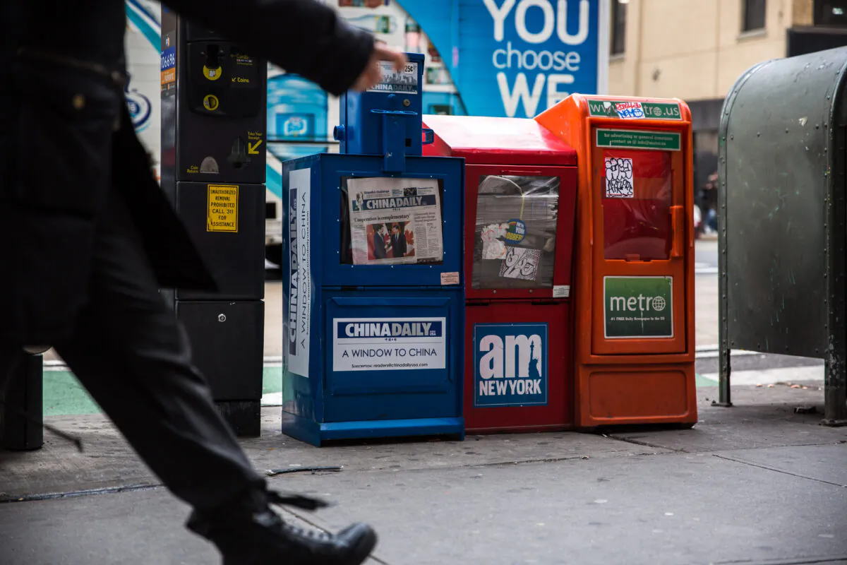 A paid China Daily newspaper box is with other free daily papers in Midtown Manhattan on Dec. 6, 2017. (Benjamin Chasteen/The Epoch Times)