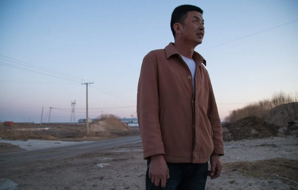 Wang Jianjun stands outside his dairy farm while worrying about the market in Hulunbuir, Inner Mongolia, China on May 1, 2019. (Betsy Joles/ Getty Images)