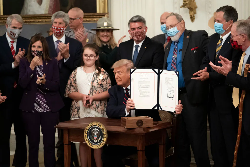 President Donald Trump signs the Great American Outdoors Act during a singing ceremony in the East Room of the White House in Washington, on Aug. 4, 2020. (Drew Angerer/Getty Images)
