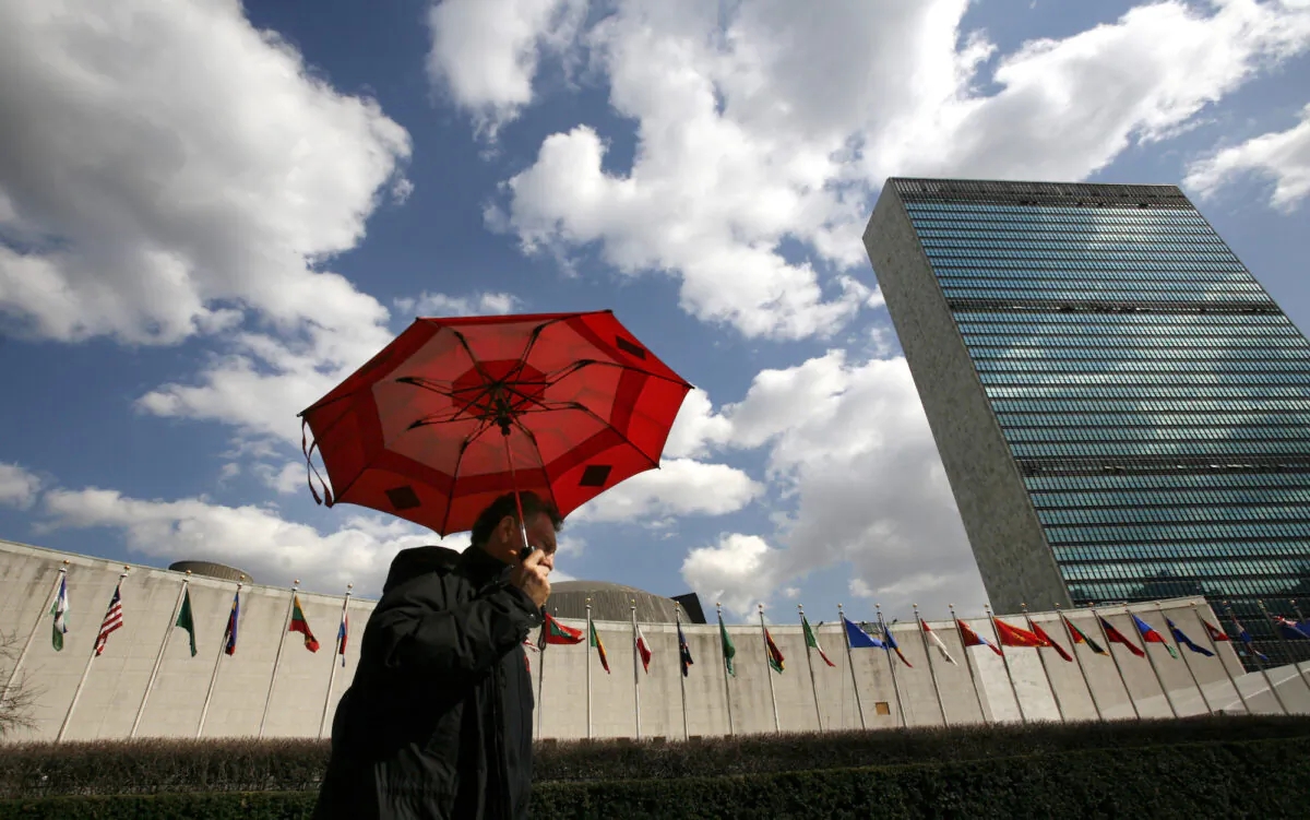 A man holding an umbrella passes the UN Headquarters in New York, on March 24, 2008. (Mike Segar/Reuters)