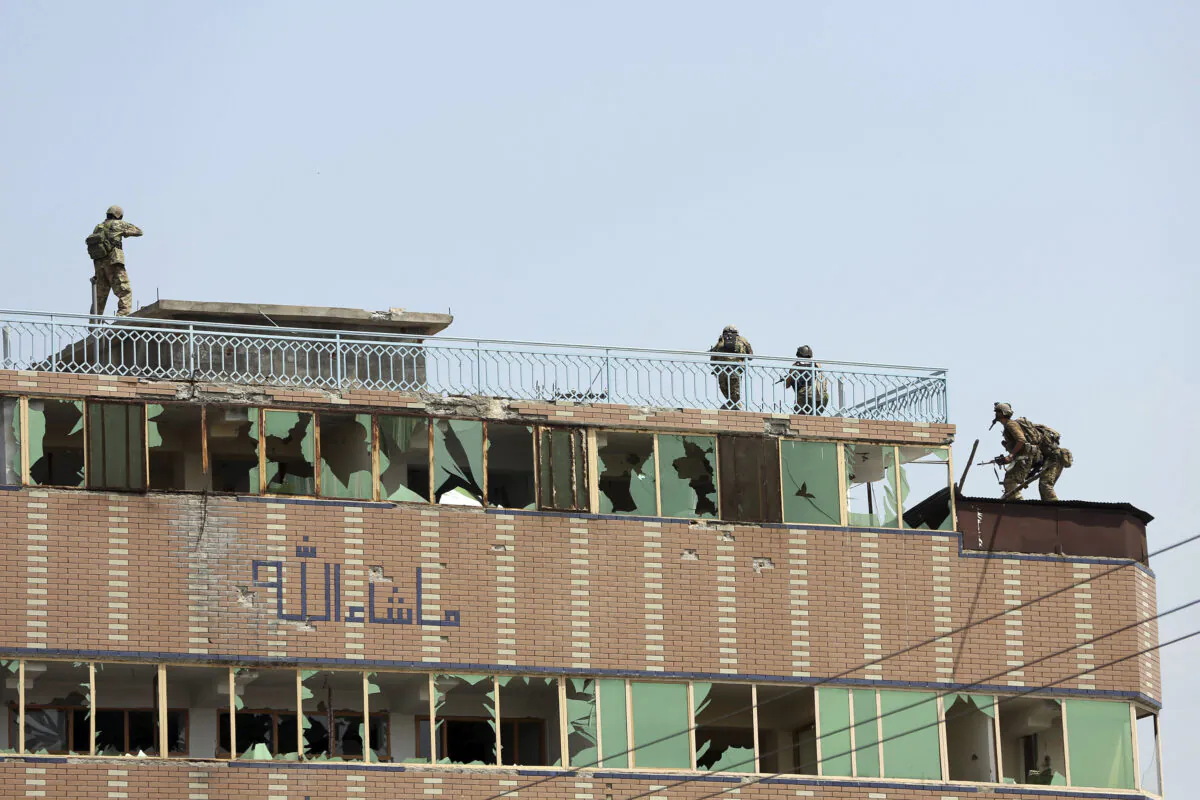 Afghan security personnel take position on top of a building where insurgents are hiding, in the city of Jalalabad, Afghanistan, on Aug. 3, 2020.  (AP Photo/Rahmat Gul)