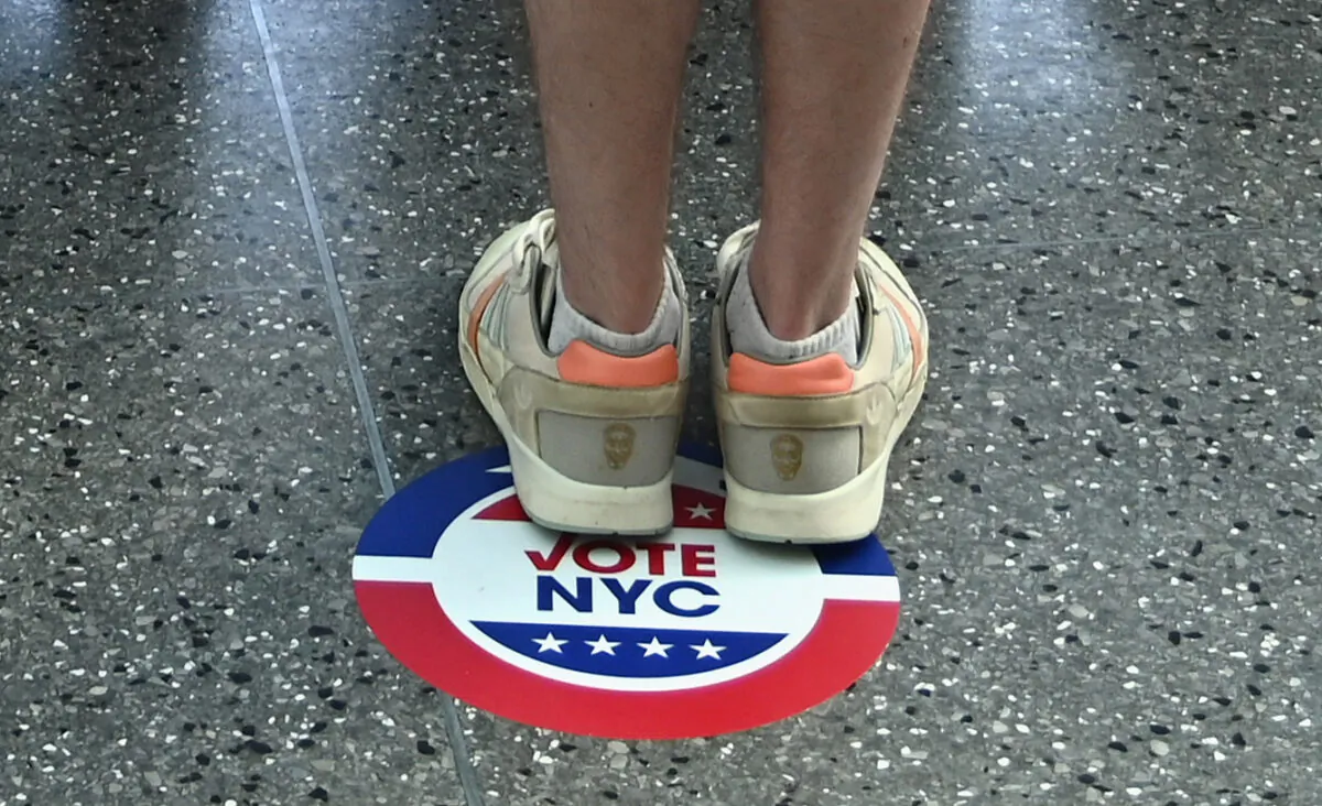 A voter stands on a Vote NYC sticker to encourage social distancing during the New York Democratic presidential primary elections in New York on June 23, 2020. (Angela Weiss/AFP via Getty Images)