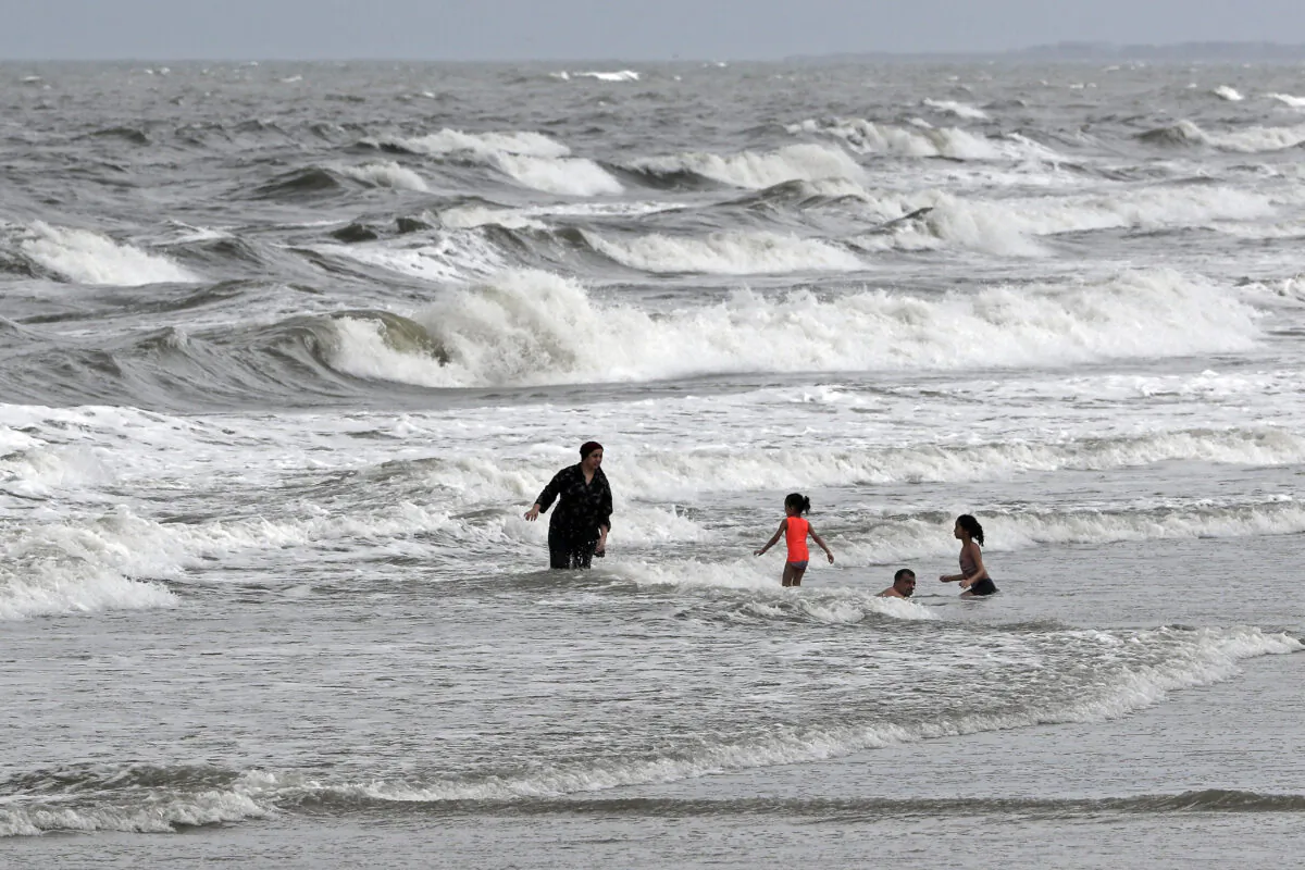 People swim in the ocean as Tropical Storm Isaias approaches in Kure Beach, N.C., on Aug. 3, 2020. (Gerry Broome/AP Photo)