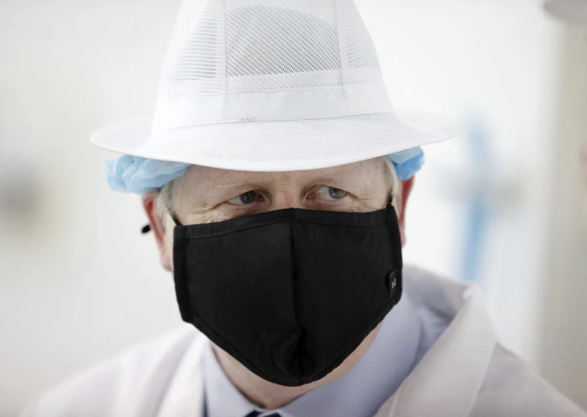 Britain's Prime Minister Boris Johnson wearing a black face mask with the number 10 , at Orkney Cheese in Kirkwall, during a visit to the Highlands and Northern Isles of Scotland, on July 23, 2020. (Robert Perry/PA via AP Photo)