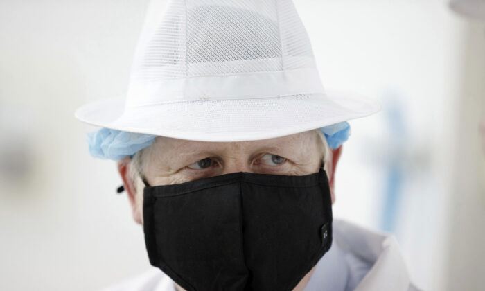 Britain's Prime Minister Boris Johnson wearing a black face mask with the number 10 , at Orkney Cheese in Kirkwall, during a visit to the Highlands and Northern Isles of Scotland, on July 23, 2020. (Robert Perry/PA via AP Photo)