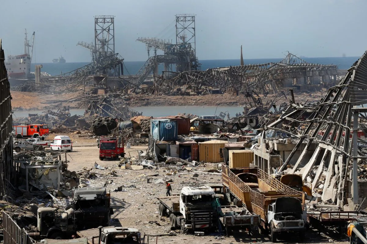 Rescue workers and security officers work at the site of an explosion that hit the seaport of Beirut, Lebanon, Wednesday, Aug. 5, 2020. Residents of Beirut stunned, sleepless and stoic emerged Wednesday from the aftermath of a catastrophic explosion searching for missing relatives, bandaging their wounds and retrieving what's left of their homes. (AP Photo/Hussein Malla)