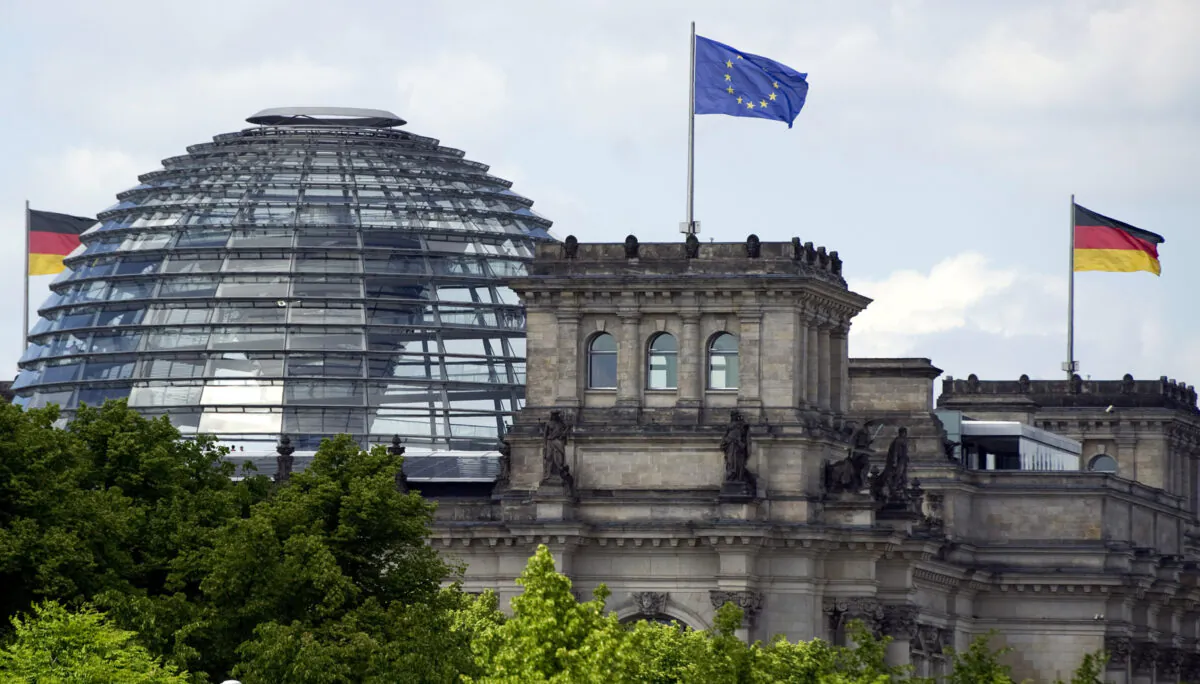A European Union flag and a German national flag fly over the Reichstag building in Berlin, Germany, on May 25, 2011. (Johannes Eisele/AFP via Getty Images)