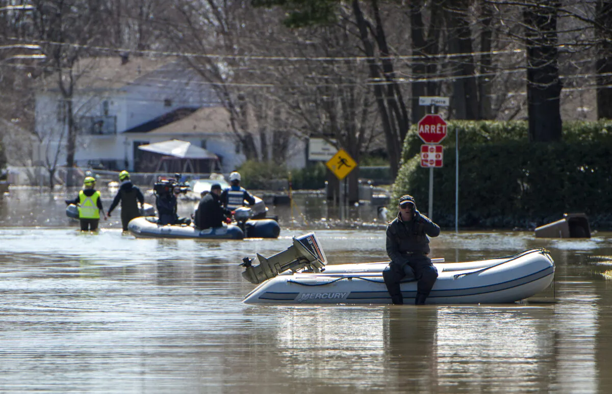 An operation to rescue pets from homes that had to be abandoned during evacuations is underway on a flooded street in the Montreal suburb of Sainte-Marthe-sur-le-Lac, Quebec, on April 29, 2019. (SEBASTIEN ST-JEAN/AFP via Getty Images)