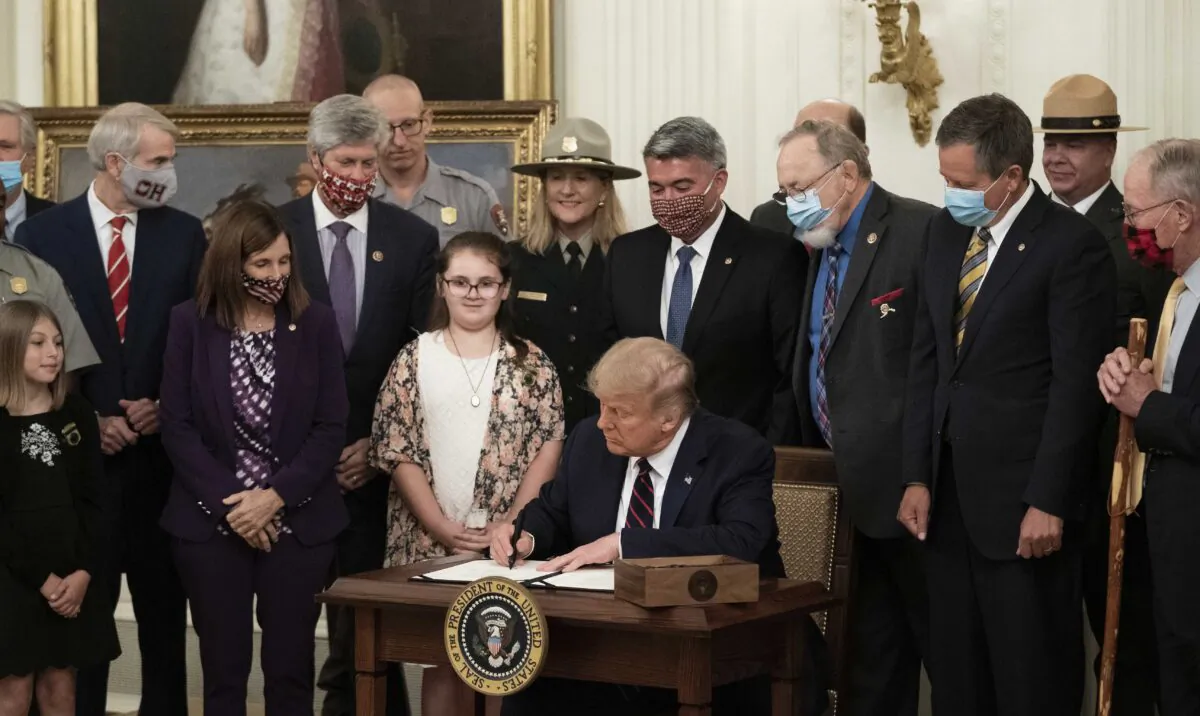 President Donald Trump signs the Great American Outdoors Act during a singing ceremony in the East Room of the White House in Washington on Aug. 4, 2020. (Drew Angerer/Getty Images)