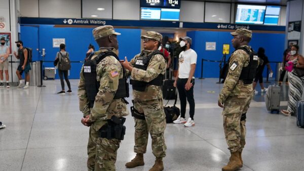 Military officials stand at Penn Station