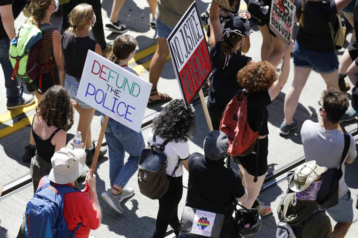 People carry signs during a "Defund the Police" march from King County Youth Jail to City Hall in Seattle on Aug. 5, 2020. (Jason Redmond/AFP via Getty Images)