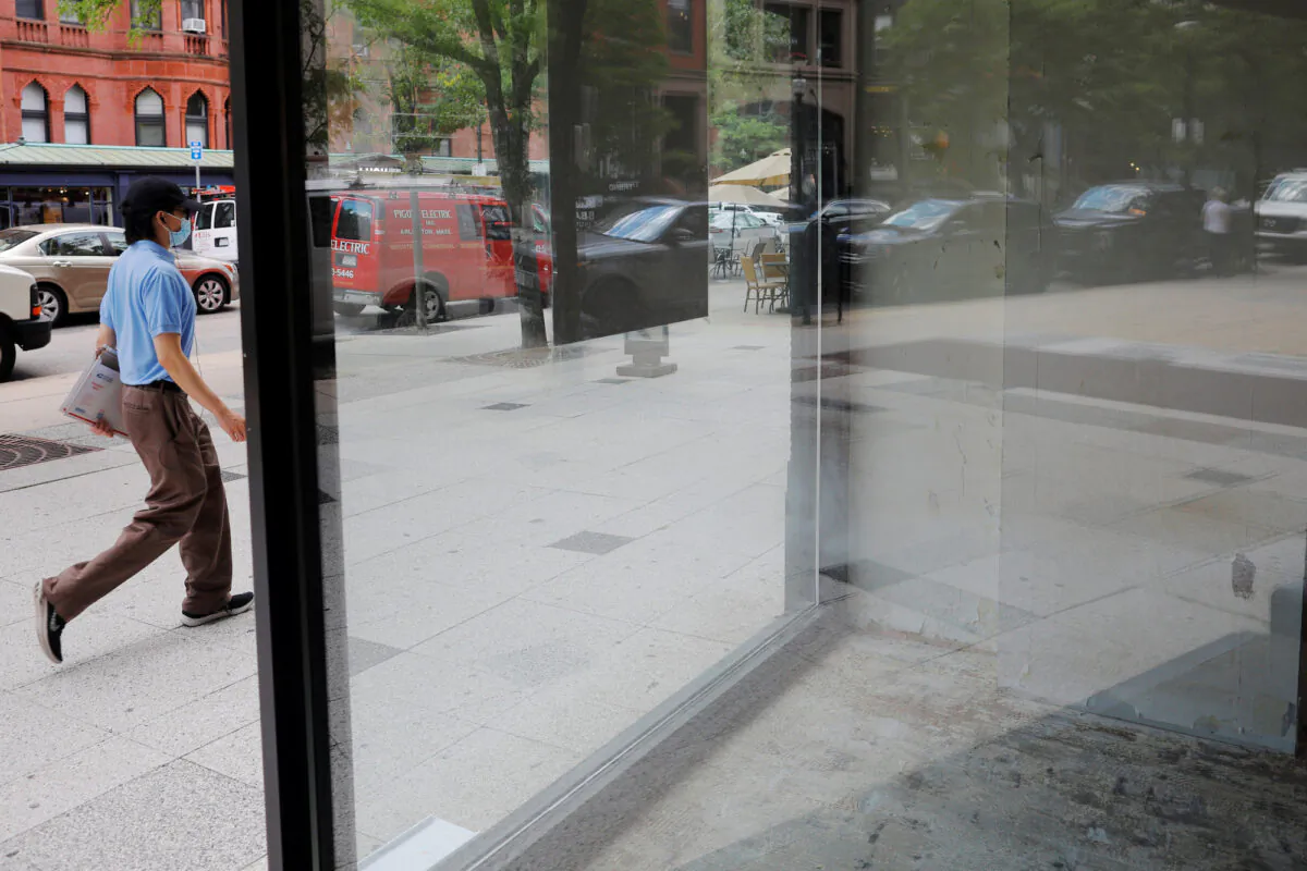 A pedestrian passes an empty storefront on Newbury Street in Boston, Mass., on Aug. 5, 2020. (Brian Snyder/Reuters)
