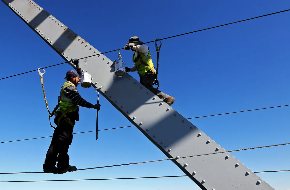File photo of workers painting the Julien Dubuque Bridge along U.S. 20 in Dubuque, Iowa, on Aug. 24, 2015. (Dave Kettering/Telegraph Herald via AP)