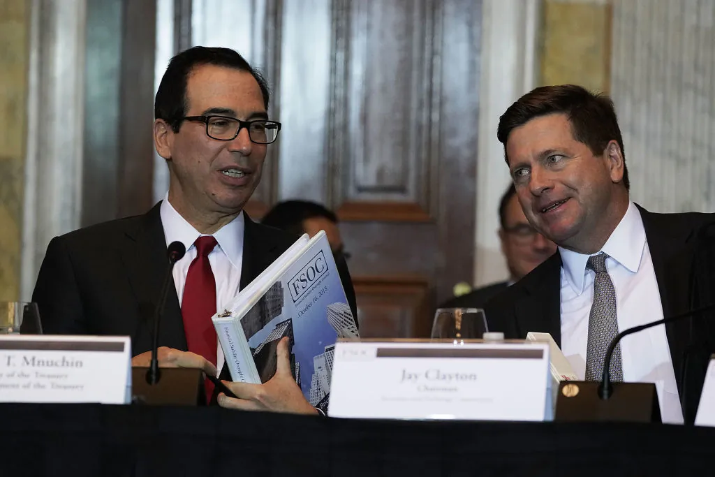 U.S. Secretary of the Treasury Steven Mnuchin (L) talks to Chairman of Securities and Exchange Commission Jay Clayton (R) during a Financial Stability Oversight Council meeting in Washington, on Oct. 16, 2018. (Alex Wong/Getty Images)