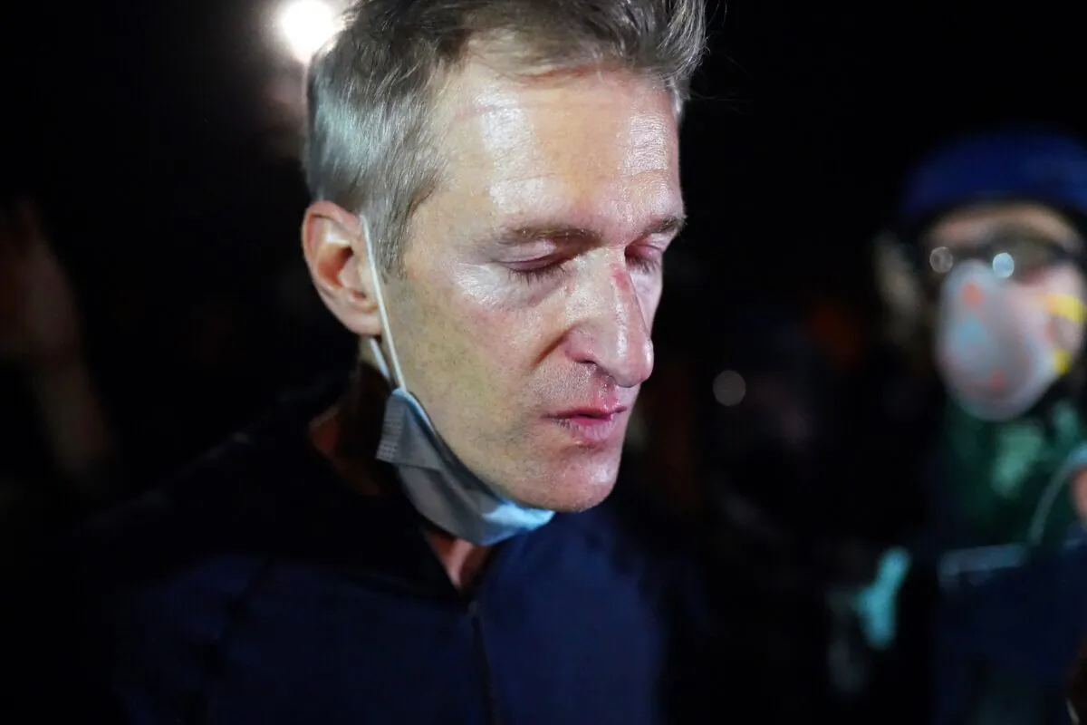 Portland Mayor Ted Wheeler reacts after being exposed to tear gas fired by federal officers while attending a violent demonstration in Portland, Ore., on July 22, 2020. (Nathan Howard/Getty Images)