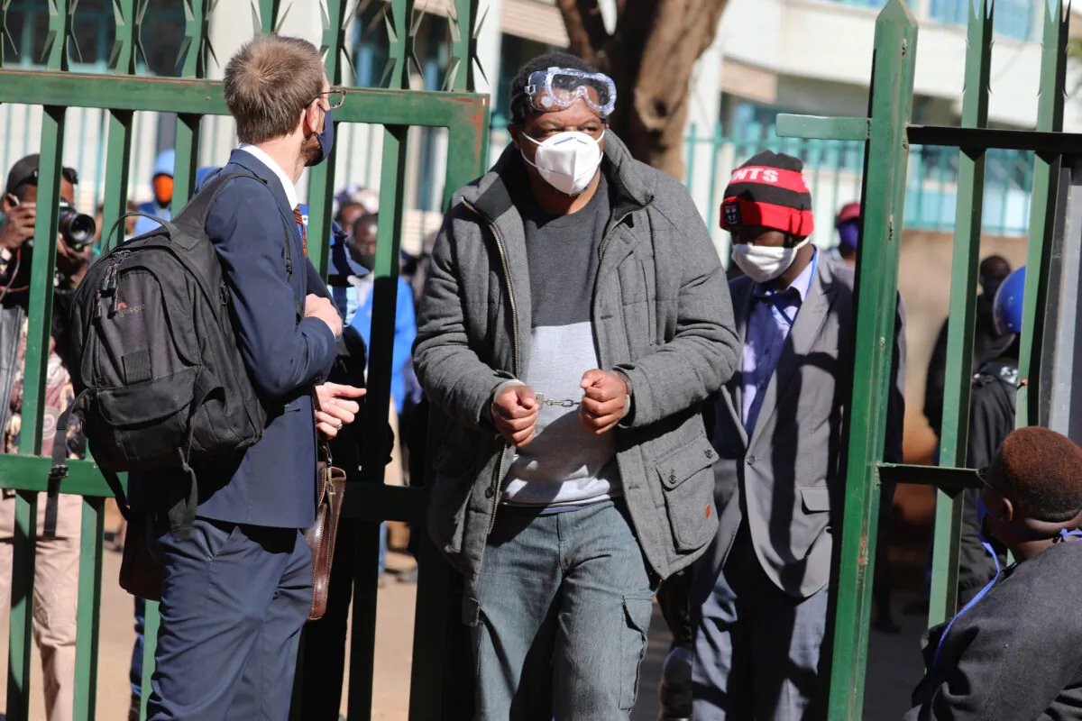 Zimbabwe journalist Hopewell Chin'ono appears at the magistrates courts while handcuffed in Harare, Wednesday, July, 22, 2020. (AP Photo/Tsvangirayi Mukwazhi)