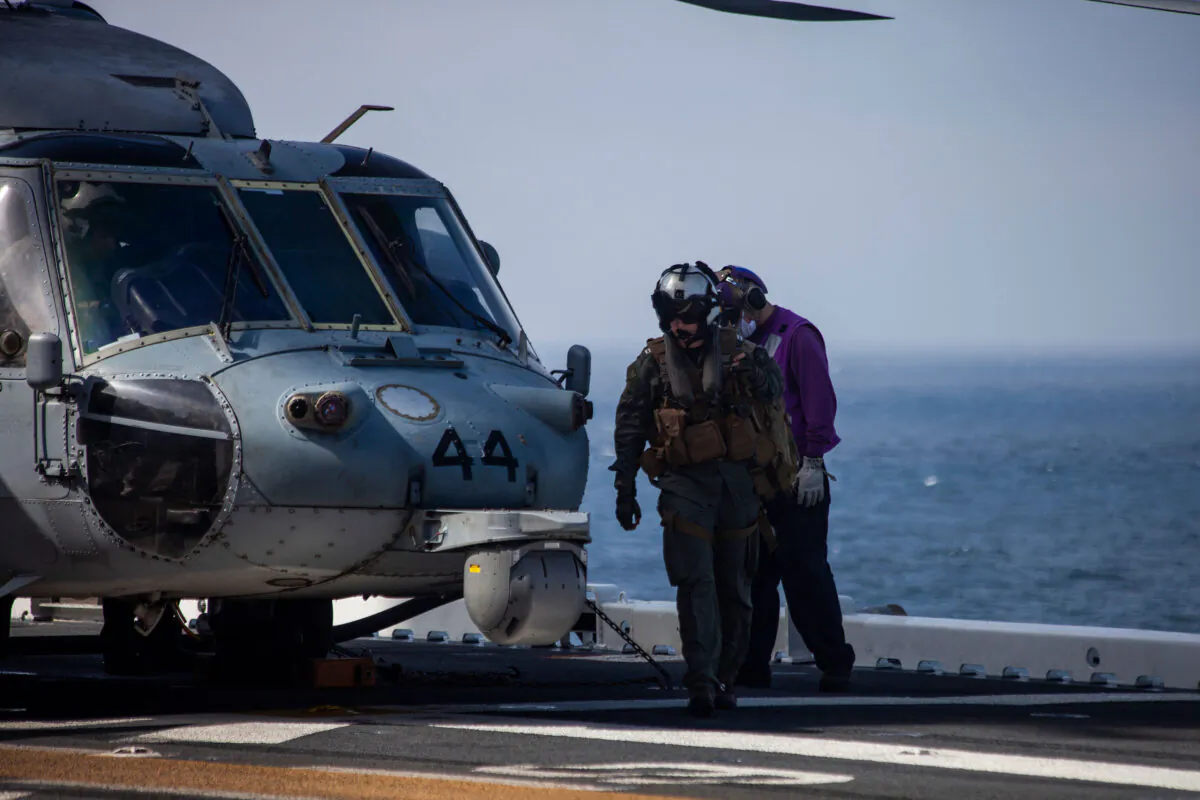 A U.S. Navy MH-60 Seahawk pilot returns to the amphibious assault ship USS Makin Island (LHD-8) during ongoing search and rescue operations following an AAV-P7/A1 assault amphibious vehicle mishap off the coast of Southern California, July 30. (Cpl. Patrick Crosley/Digital/Marine Corps)