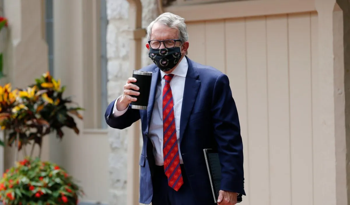 Ohio Gov. Mike DeWine acknowledges members of the media while entering his residence after testing positive for COVID-19 earlier in the day Thurs., Aug. 6, 2020, in Bexley, Ohio. DeWine tested negative later in the day using a more sensitive laboratory-developed test. (Jay LaPrete/AP photo)