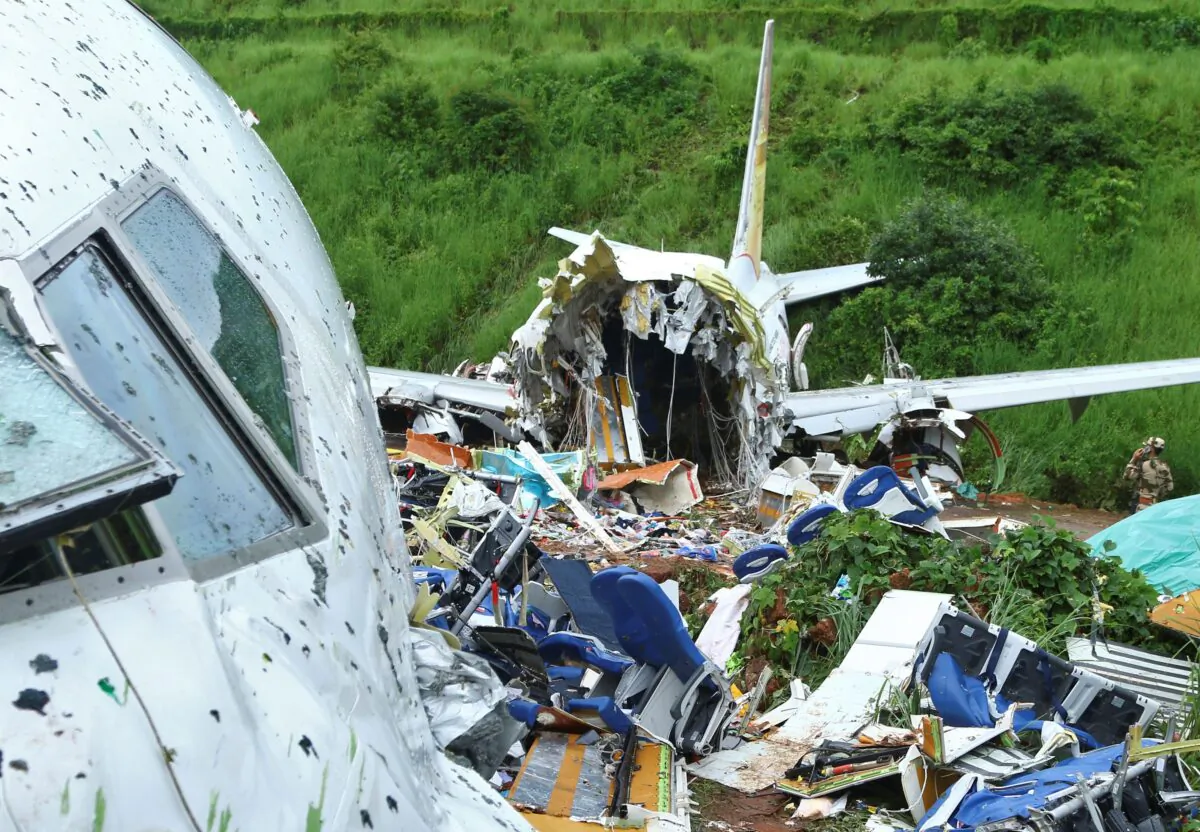 A security official inspects the site where a passenger plane crashed when it overshot the runway at the Calicut International Airport in Karipur, in the southern state of Kerala, India, Aug. 8, 2020. (Reuters/Stringer)