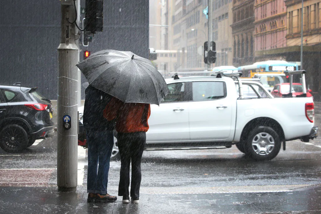 A couple brave heavy rain along Park Street in Sydney, Australia on Feb. 8, 2020. (Lisa Maree Williams/Getty Images)