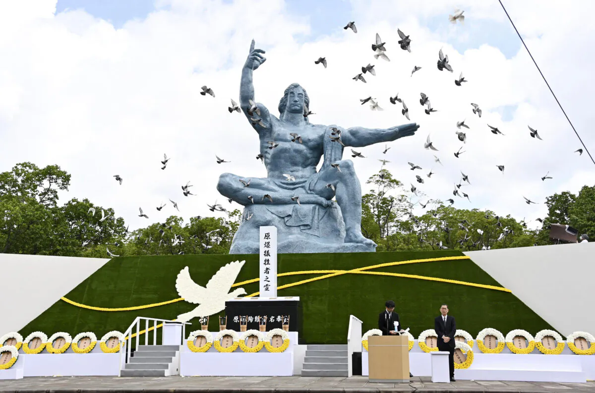 Doves fly over the Statue of Peace during a ceremony at Nagasaki Peace Park in Nagasaki, Japan, on Aug. 9, 2020. (Kyodo News via AP)