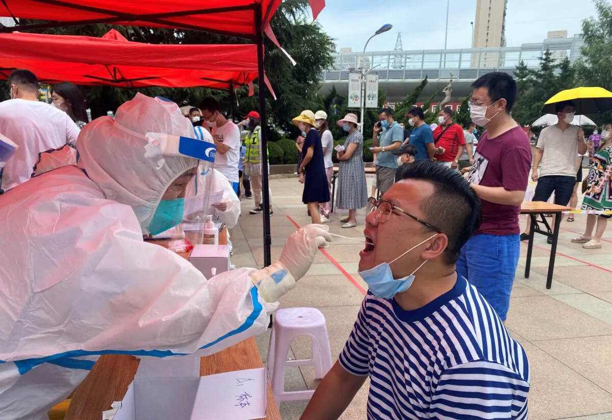 A health worker is carrying out a COVID-19 test in Dalian, in China's northeast Liaoning Province, on July 26, 2020. (STR/AFP via Getty Images)