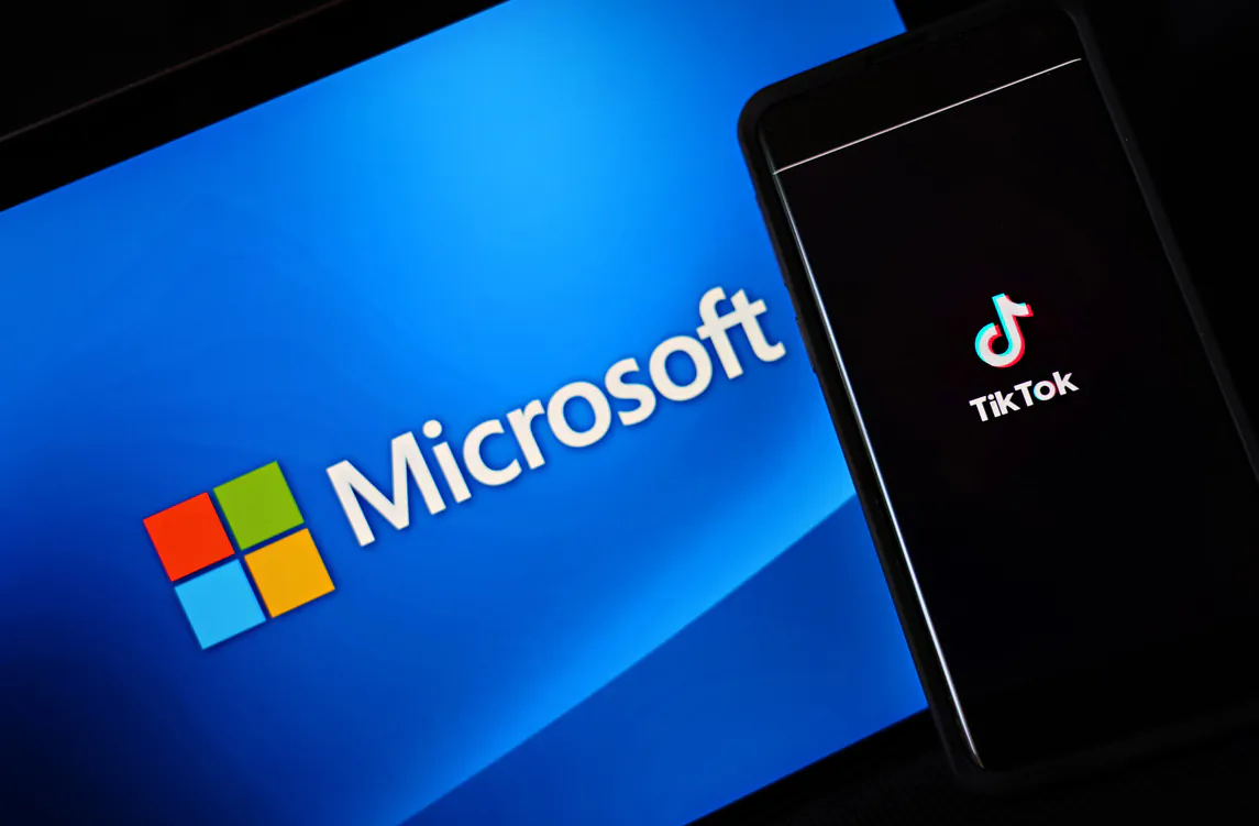 In this photo illustration, a mobile phone featuring the TikTok app is displayed next to the Microsoft logo on Aug. 3, 2020 in New York City. (Cindy Ord/Getty Images)