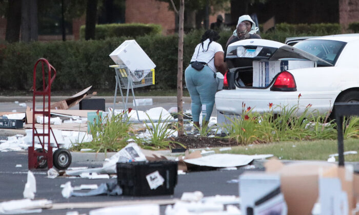 People load merchandise into a car near a looted Best Buy store after parts of the city had widespread looting and vandalism in Chicago on Aug. 10, 2020. (Scott Olson/Getty Images)