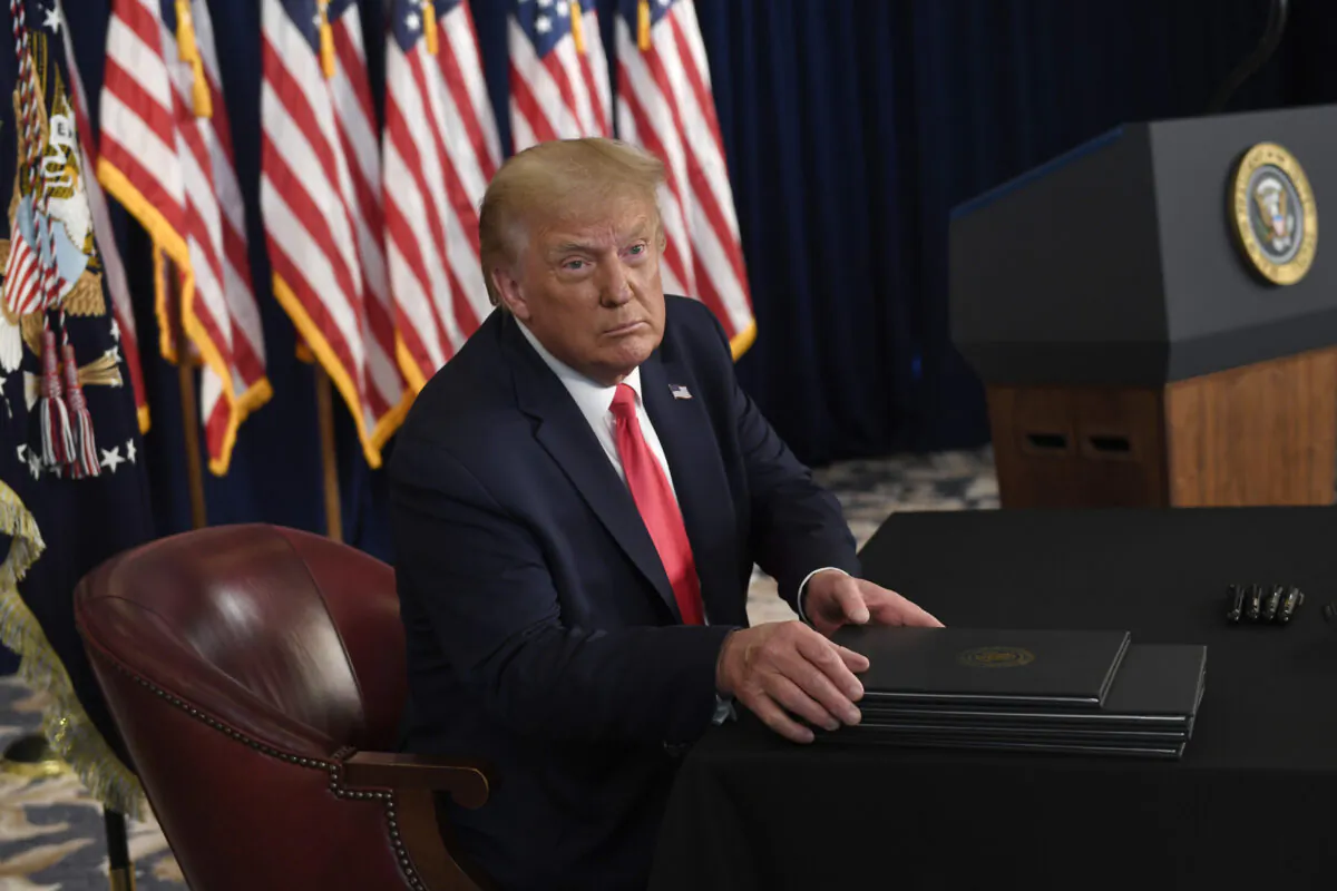 President Donald Trump prepares to sign four executive orders during a news conference at the Trump National Golf Club in Bedminster, N.J., Aug. 8, 2020. (Susan Walsh/AP Photo)