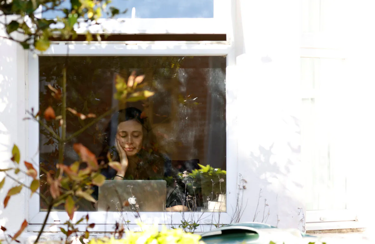A woman works from her computer at home in Oxford, England, on March 31, 2020. (REUTERS/Eddie Keogh)