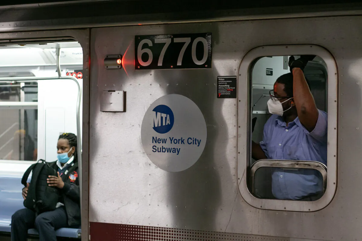 A subway team member and a passenger in the train both are wearing protective face mask in Manhattan, New York on May 4, 2020. (Chung I Ho/The Epoch Times)