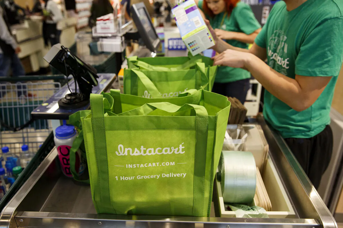 InstaCart employees fulfill orders for delivery at the new Whole Foods Market Inc. store in downtown Los Angeles, Calif., on Mon., Nov. 9, 2015. (Patrick T. Fallon/Bloomberg Photo via Getty Images)
