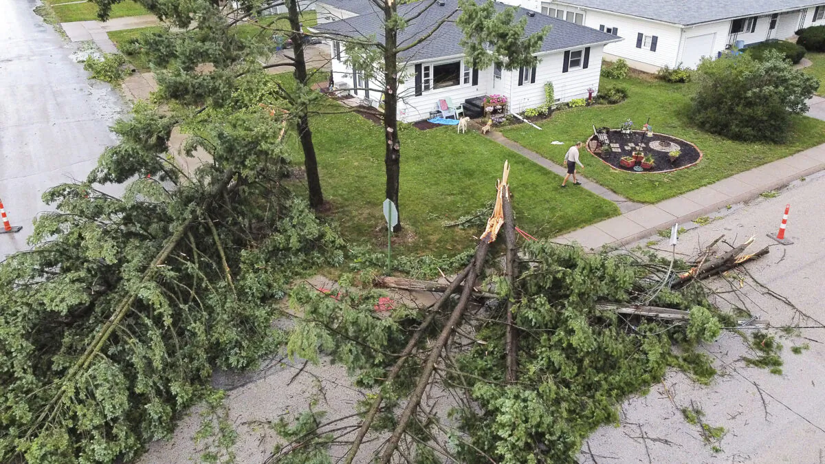 Downed trees and a utility pole in front of the home of Tim and Patricia Terres in Walcott, Iowa, after high winds and heavy rain passed through the area in Davenport, Iowa, on Aug. 10, 2020. (Kevin E. Schmidt/Quad City Times via AP)
