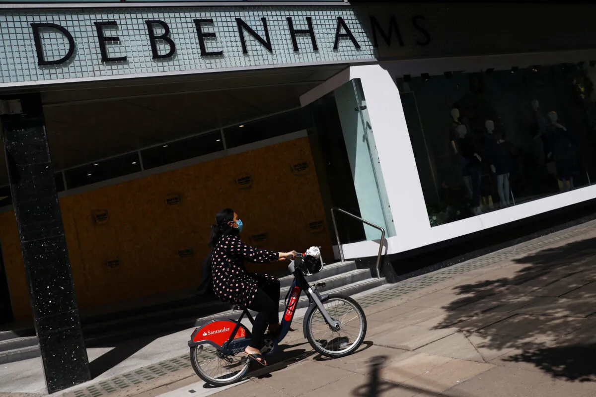 A cyclist wearing a mask goes past Debenhams in Oxford Circus, London, on May 28, 2020. (Hannah McKay/ Reuters)