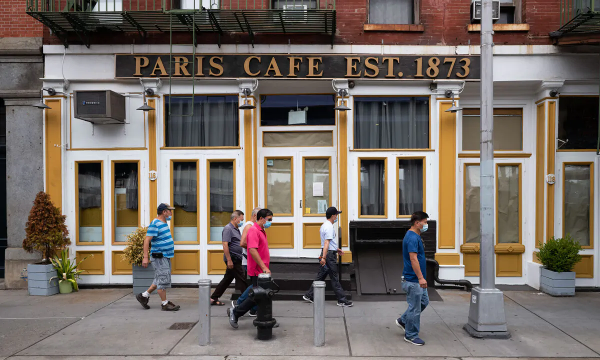 People walk by the Paris Cafe in New York's South Street Seaport on Aug. 4, 2020. (AP Photo/Mark Lennihan)