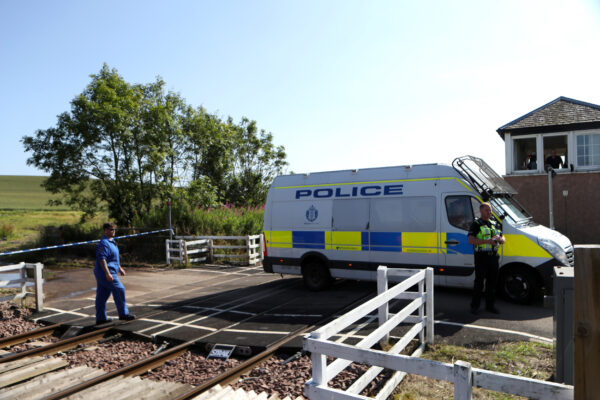 A police vehicle crosses the tracks