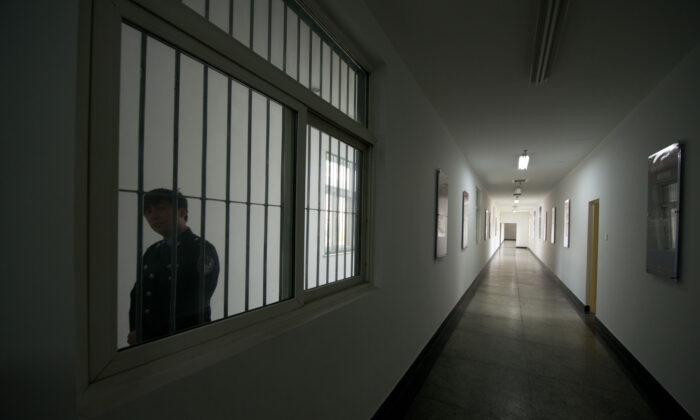 A guard looks through the window of a hallway inside the No. 1 Detention Center during a government guided tour in Beijing on Oct. 25, 2012. (Ed Jones/AFP via Getty Images)