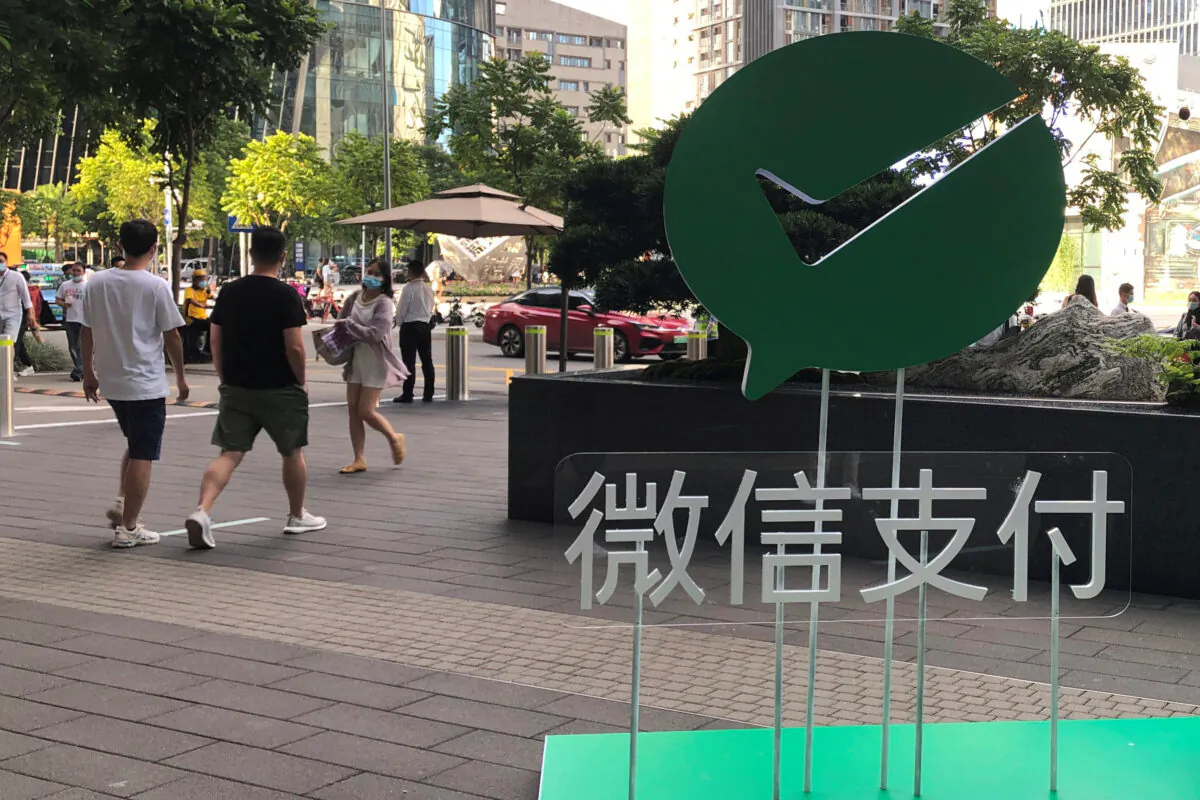 People walk past a Wechat Pay sign at the Tencent company headquarters in Shenzhen, Guangdong province, China on Aug. 7, 2020. (Reuters/David Kirton)