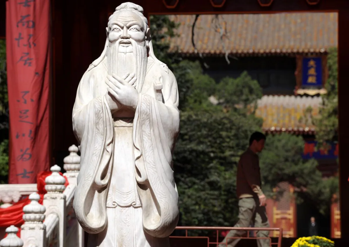 A man walks beside a statue of Confucius at the Confucius Temple in Beijing, China, on Sept. 28, 2010. (Liu Jin/AFP via Getty Images)