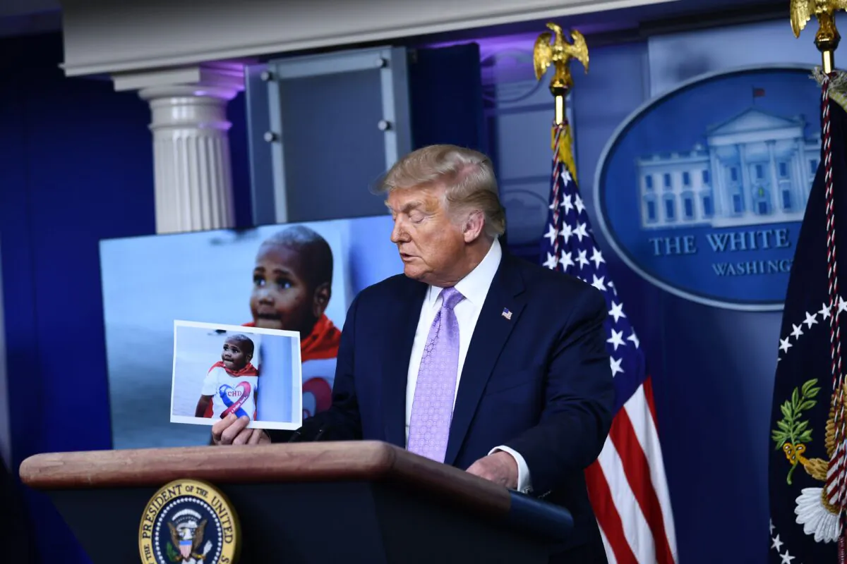 President Donald Trump holds up a photo of LeGend Taliferro, a victim of a crime, during a news conference in the Brady Briefing Room of the White House in Washington on Aug. 13, 2020. (Brendan Smialowski/AFP/Getty Images) 