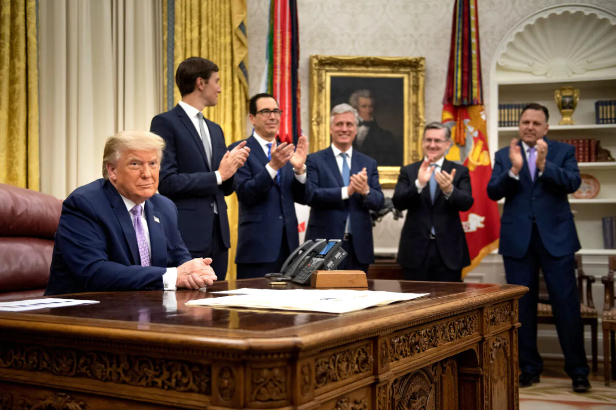 (L-R, rear) Senior Advisor Jared Kushner, Secretary of the Treasury Steven Mnuchin, National Security Advisor Robert O'Brien and others clap for President Donald Trump (L) after he announced an agreement between the United Arab Emirates and Israel to normalize diplomatic ties, the White House on Aug. 13, 2020. (Brendan Smialowski/AFP via Getty Images)