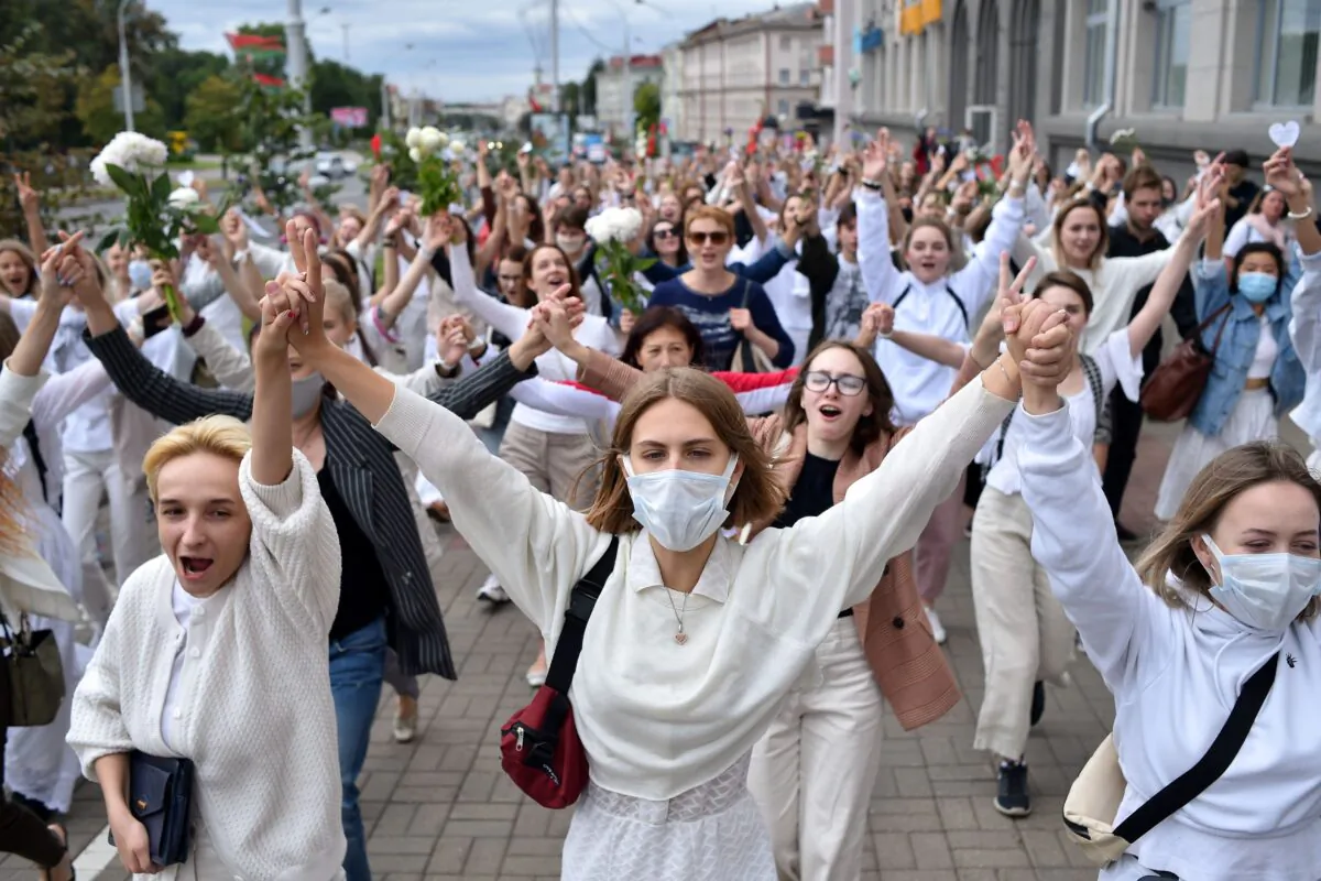 Women dressed in white clothes protest against police violence during recent rallies of opposition supporters, who accuse strongman Alexander Lukashenko of falsifying the polls in the presidential election, in Minsk on Aug. 12, 2020. (Sergei Gapon/AFP via Getty Images)